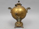 an antique brass urn with a bird on the top of it