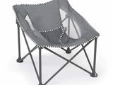 La chaise pliante est grise et est surmontée de deux coussins.