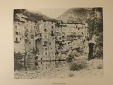 a black and white photo of an old town in the mountains