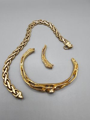 une photo représentant un collier et un bracelet en or posés sur une surface grise