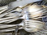 un panier rempli de cuillères et de fourchettes en argent
