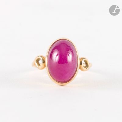 gros plan d'une bague en pierre rose sur une surface blanche