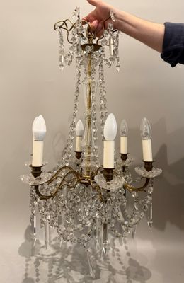 a person pointing at a chandelier that is hanging from the ceiling