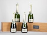 trois bouteilles de champagne dans un coffret en bois sur fond blanc