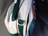 a white bag with a green and orange stripe on it