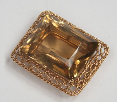 a close up of a golden colored stone with a chain around it
