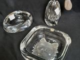 two clear glass ashtrays and a glass ashtray on a black background
