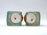 pair of green glass salt and pepper shakers on white background