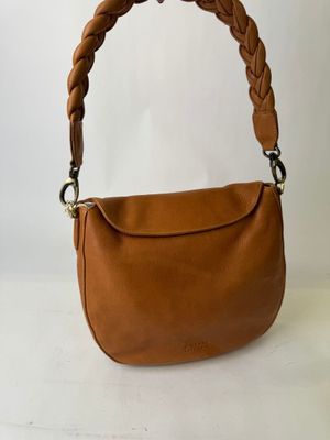un sac à main en cuir marron avec des anses tressées, sur fond blanc