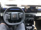 someone is sitting in the driver ' s seat of a car with their feet on the steering wheel