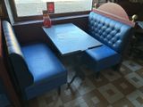 a blue booth with a blue table and two blue chairs