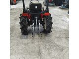 the tractor is parked in a warehouse with other machinery in the background
