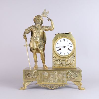 a gold clock with a man standing next to it