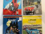 four comic books sitting on top of a table next to each other