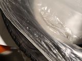 a motorcycle that is wrapped in plastic and sitting on the floor