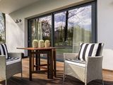 une terrasse avec deux chaises et une table