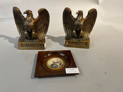 une paire de serre-livres en bronze représentant des aigles, avec l'effigie d'un homme et d'une femme