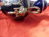 a blue and gold vase on a red table cloth
