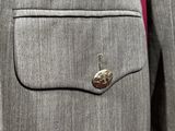 a close up of a suit with a button on the lapel