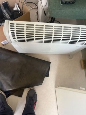une personne debout devant un radiateur posé au sol