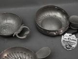 many metal pans and spoons sitting on a table