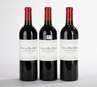 trois bouteilles de vin rouge posées sur une table