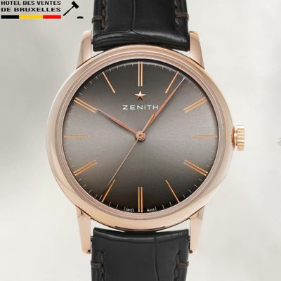 a close up of a wrist watch with a black dial on a black leather strap