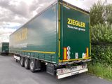 a green semi truck that is parked on the side of the road