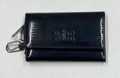étui à cartes de visite en cuir avec des initiales gravées sur un fond blanc