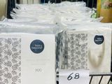 une personne tenant un paquet de papier toilette dans un magasin