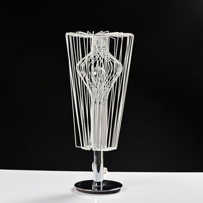 une sculpture en fil de fer représentant un vase posé sur une table