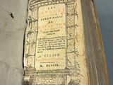 quelqu'un tient un livre ouvert à une page où figure une illustration
