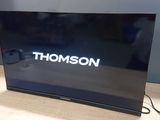 un téléviseur posé sur une table, avec une télécommande dessus