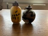 deux petits vases posés l'un à côté de l'autre sur une table