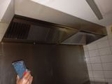 une personne tenant un téléphone portable à la main dans une cuisine