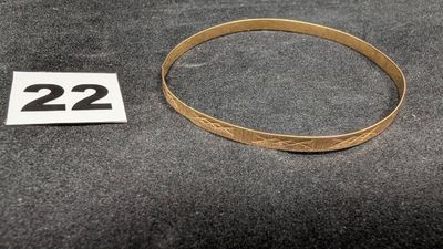 un gros plan d'un bracelet en or sur lequel figure le chiffre 22