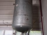 a large metal tank sitting on top of a wooden stand