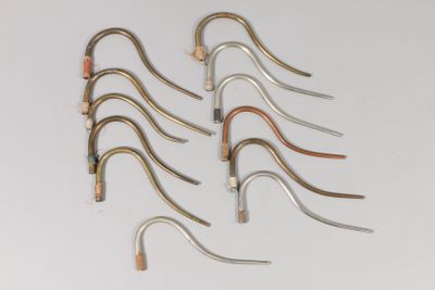 six pairs of metal hooks are arranged in a row on a white surface