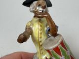 a figurine of a man with a drum in his hand