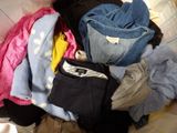 a pile of clothes sitting on top of a bed