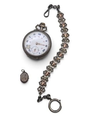 a pocket watch with a chain around it on a white surface