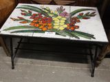 une table en carrelage décorée de fleurs, dans une pièce