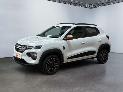 La voiture blanche est garée dans une grande pièce au sol noir.