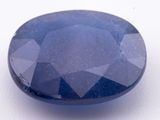 a blue sapphire stone on a white surface