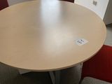 an image of a round table with red chairs