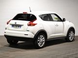 the rear end of a white nissan juke suv parked in a garage