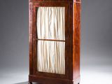 une armoire ancienne en bois avec une porte vitrée et un rideau