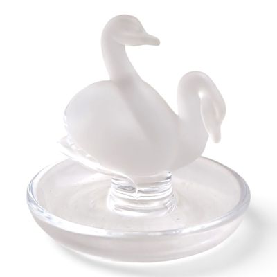 a glass swan sitting on top of a glass plate