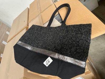 un sac noir et argent posé sur une boîte en carton