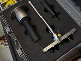 a tool in a case on the floor next to a pair of shoes